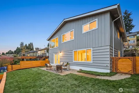 a view of backyard with swimming pool and seating space