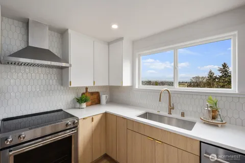 a kitchen with a sink a stove cabinets and a window