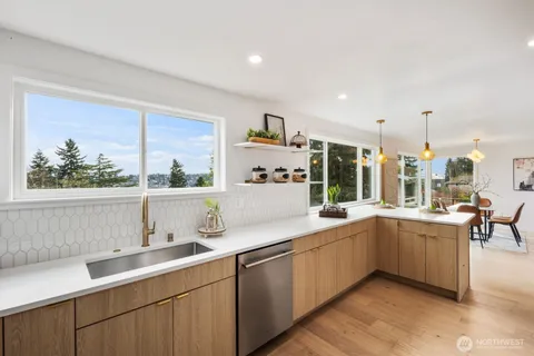 a kitchen with a sink and large windows