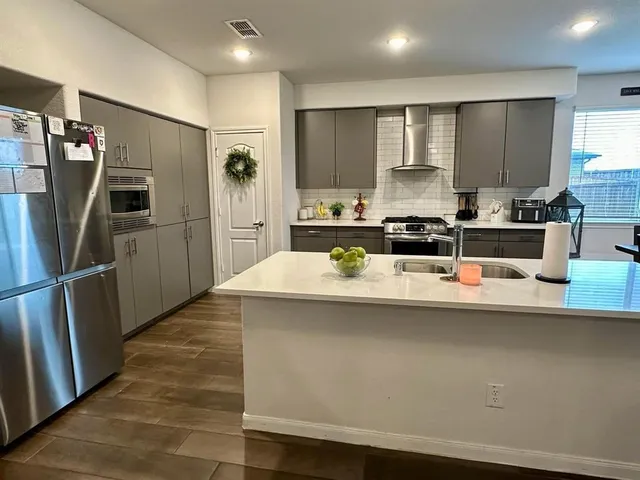 a kitchen with kitchen island a sink stove and refrigerator