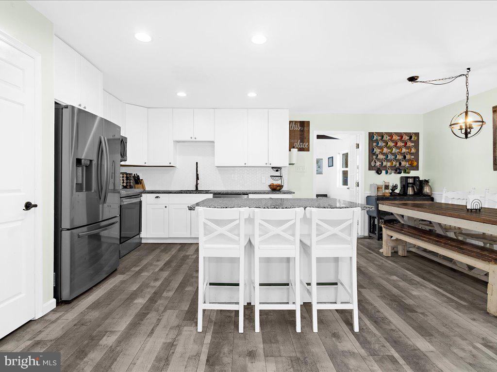 251 Ullman Road Pasadena, MD 21122 - Photo 5 of 29 a kitchen with stainless steel appliances kitchen island granite countertop a refrigerator and a stove top oven