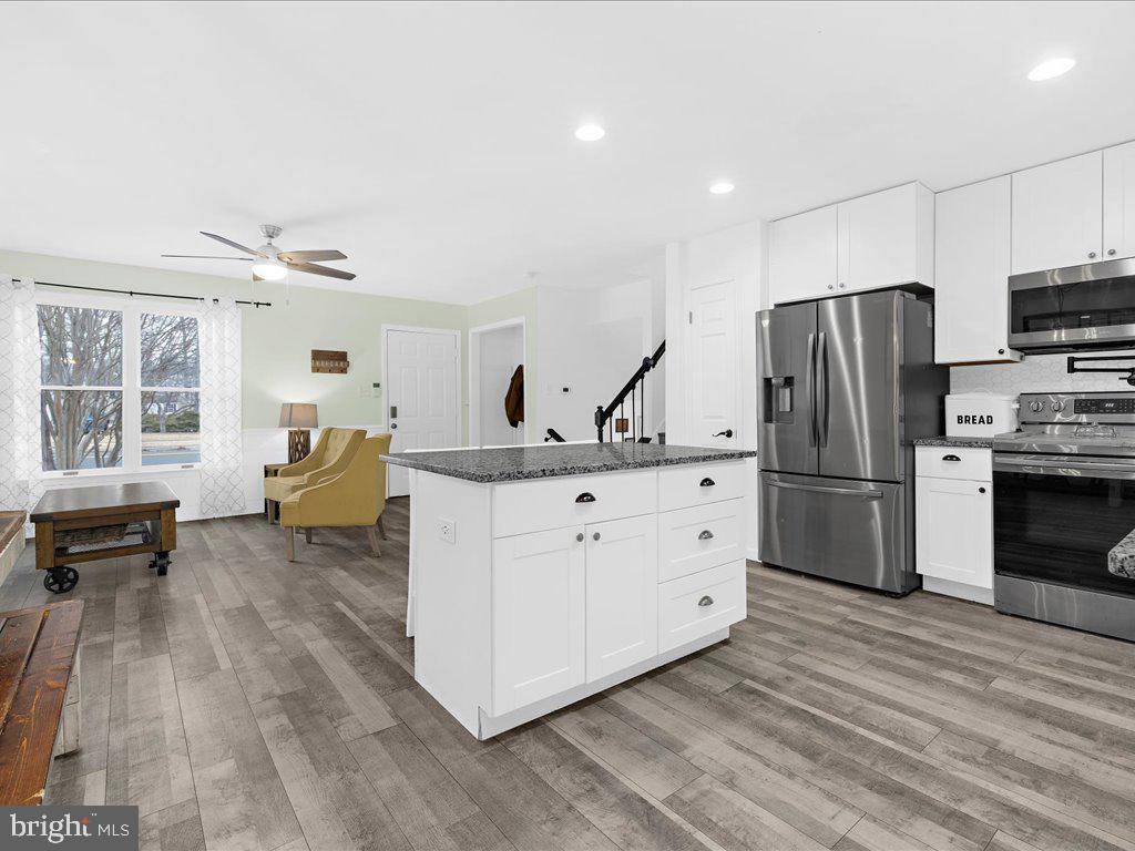 251 Ullman Road Pasadena, MD 21122 - Photo 6 of 29 a kitchen with white cabinets and stainless steel appliances