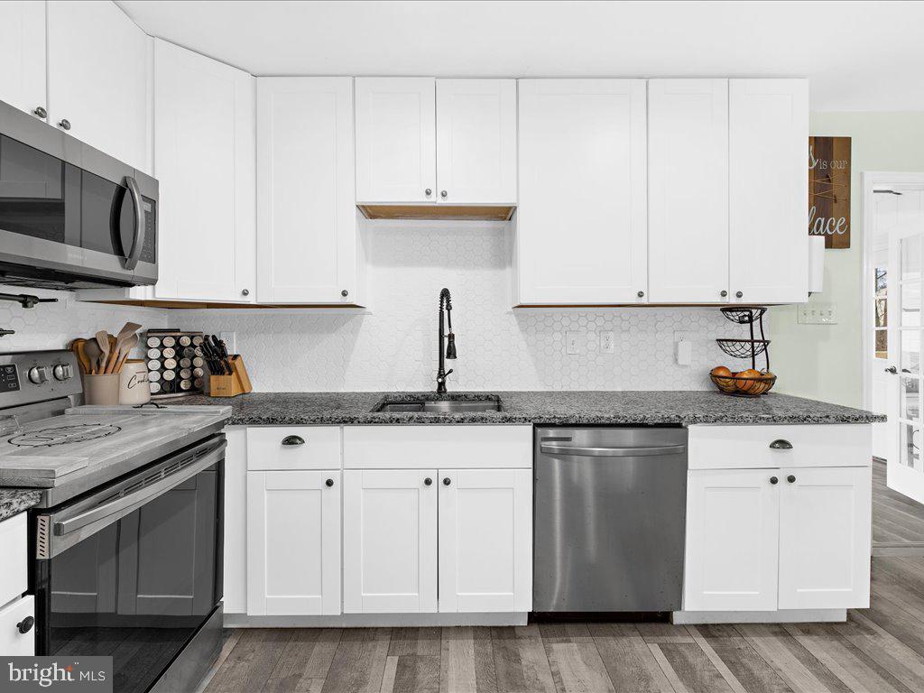 251 Ullman Road Pasadena, MD 21122 - Photo 7 of 29 a kitchen with granite countertop white cabinets and stainless steel appliances