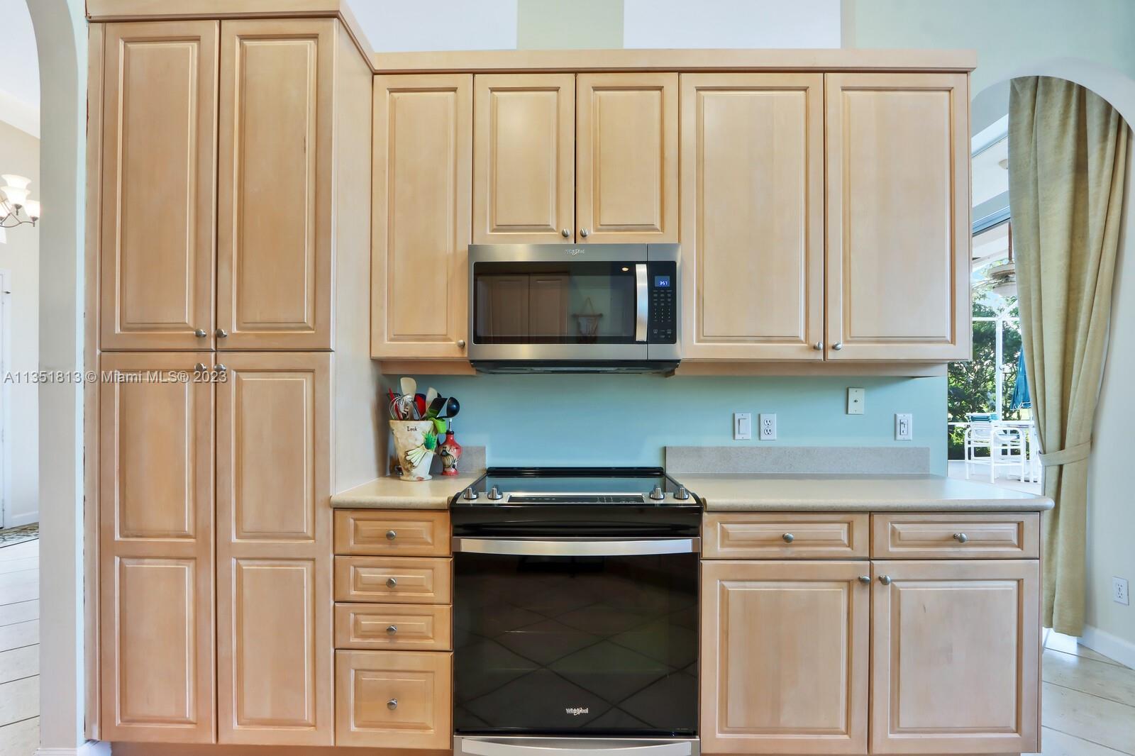 1237 Southwest Blue Stem Way Stuart, FL 34997 - Photo 16 of 48 a kitchen with granite countertop white cabinets and stainless steel appliances