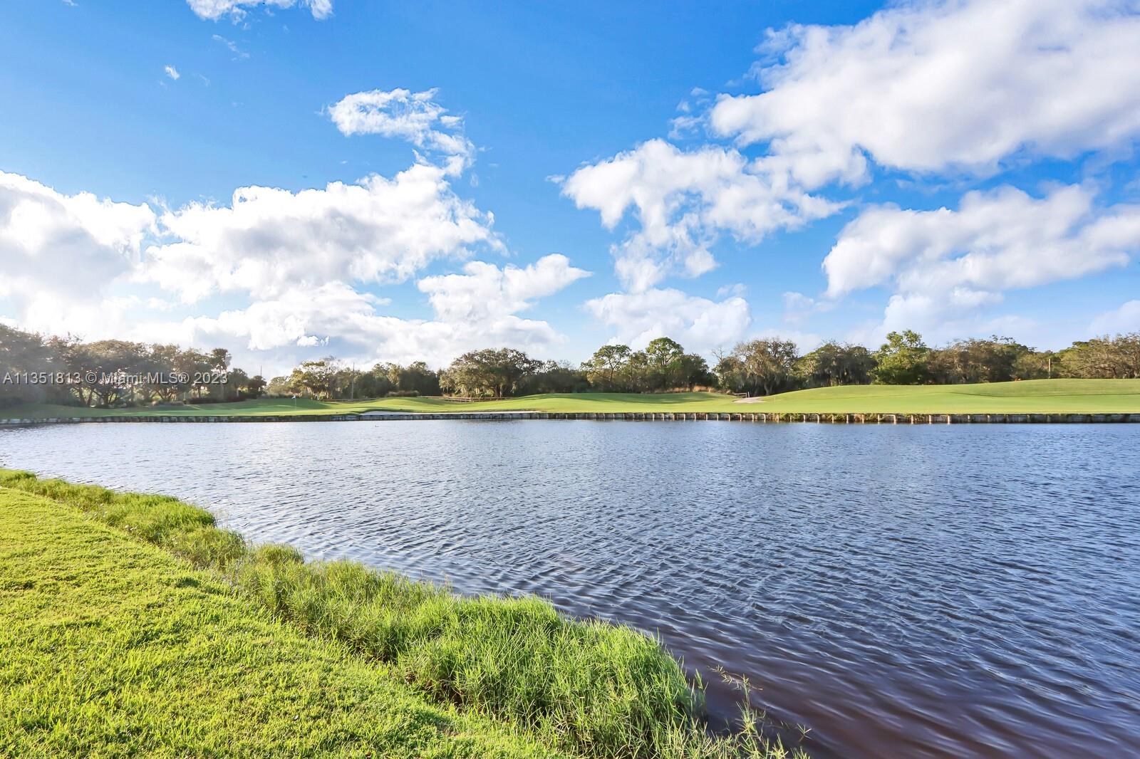 1237 Southwest Blue Stem Way Stuart, FL 34997 - Photo 2 of 48 a view of a lake with a big yard