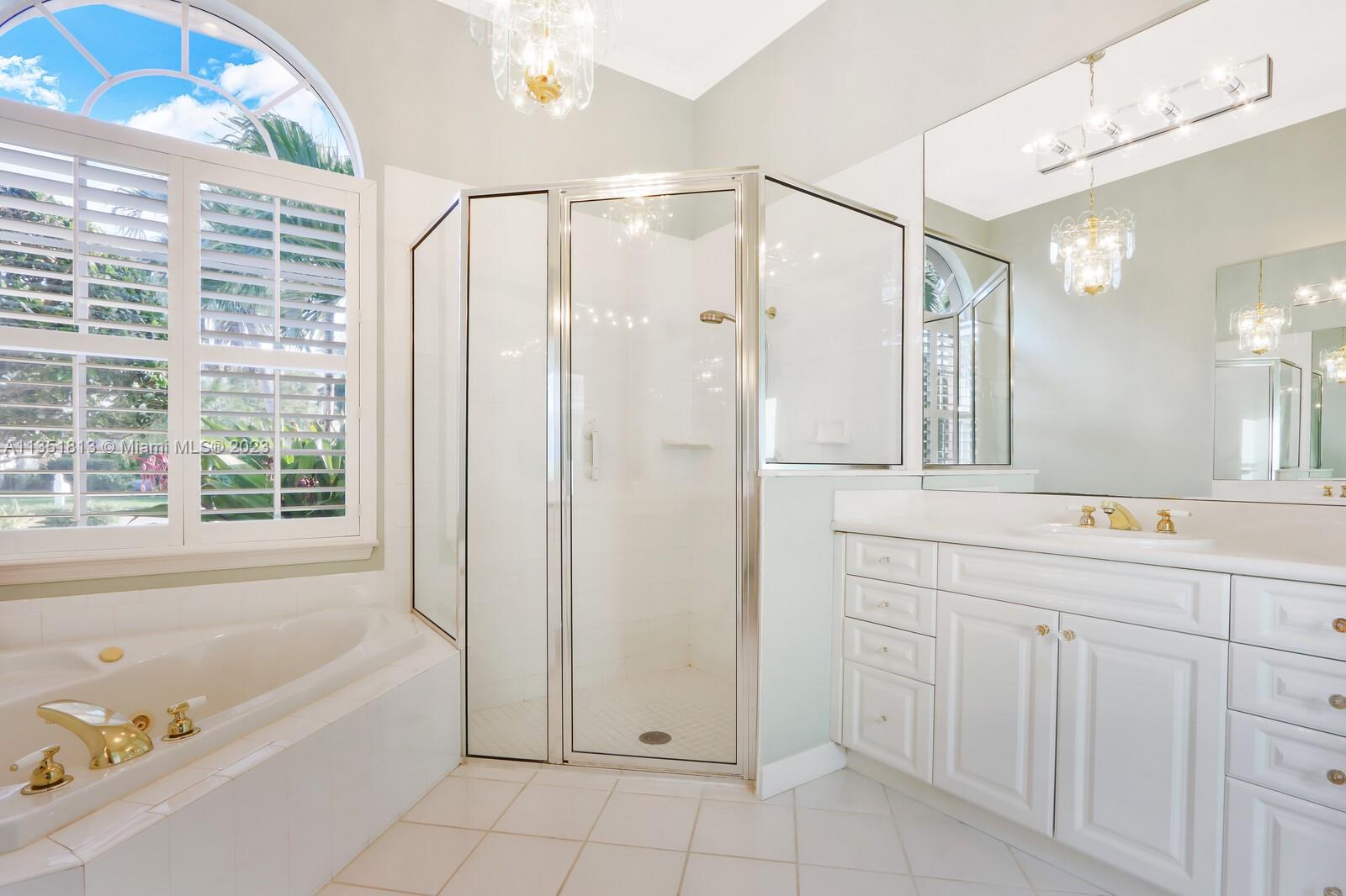 1237 Southwest Blue Stem Way Stuart, FL 34997 - Photo 26 of 48 a bathroom with a bathtub a sink a vanity a window and a shower