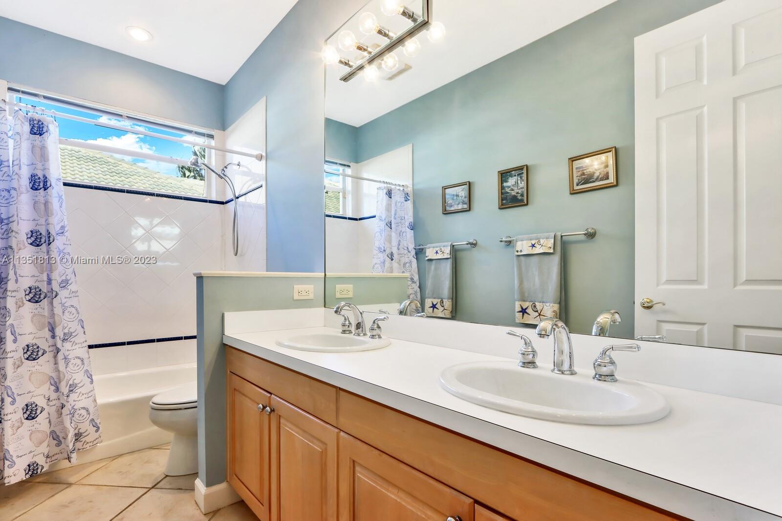 1237 Southwest Blue Stem Way Stuart, FL 34997 - Photo 30 of 48 a bathroom with a double vanity sink mirror and