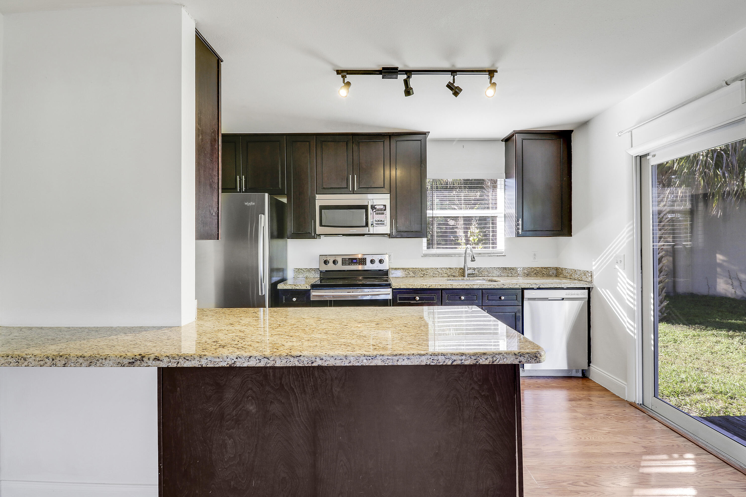 6264 Allen Street Jupiter, FL 33458 - Photo 13 of 27 a kitchen with stainless steel appliances granite countertop a sink a stove and a refrigerator