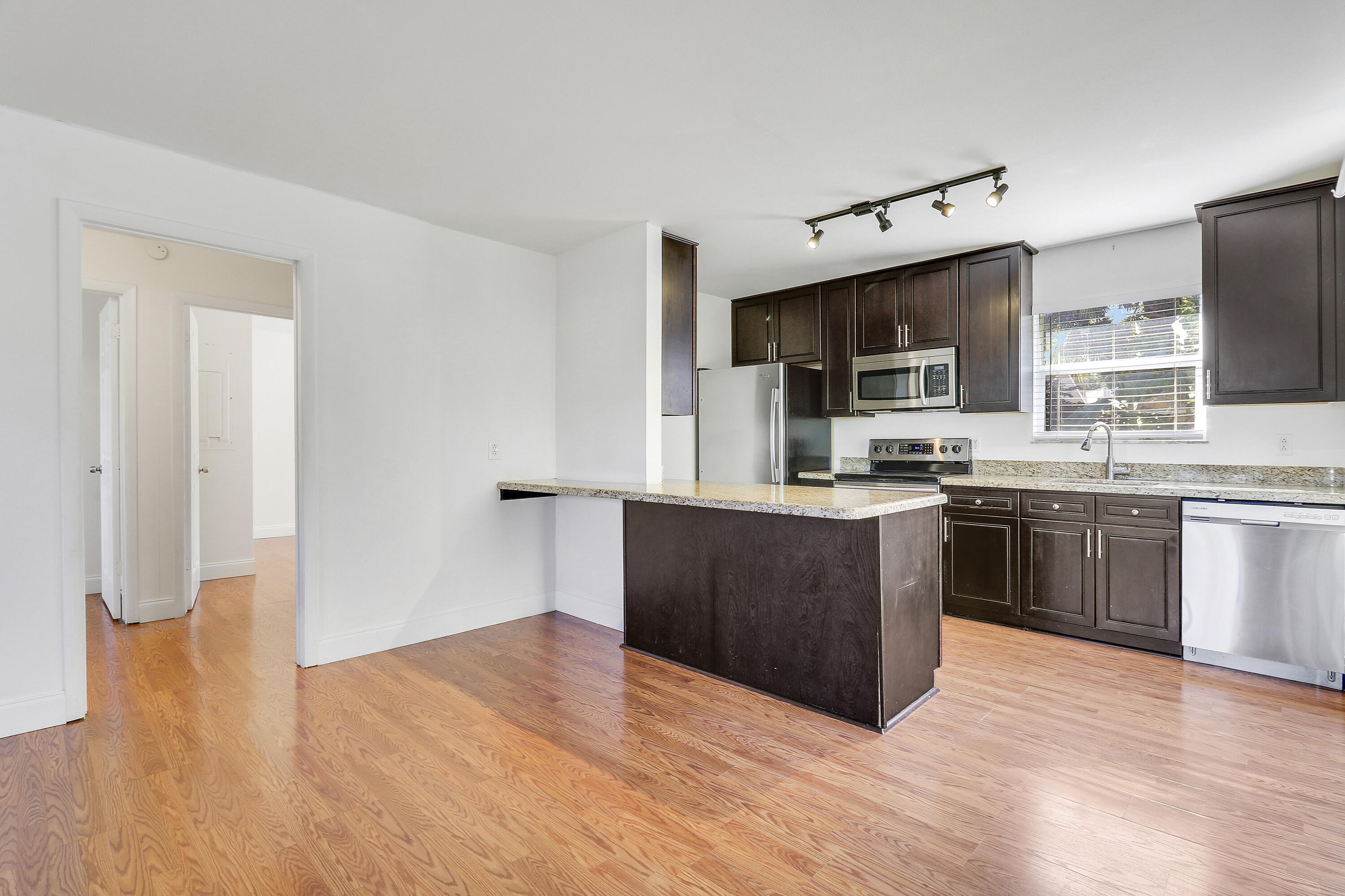6264 Allen Street Jupiter, FL 33458 - Photo 16 of 27 a kitchen with stainless steel appliances kitchen island granite countertop a stove top oven and sink