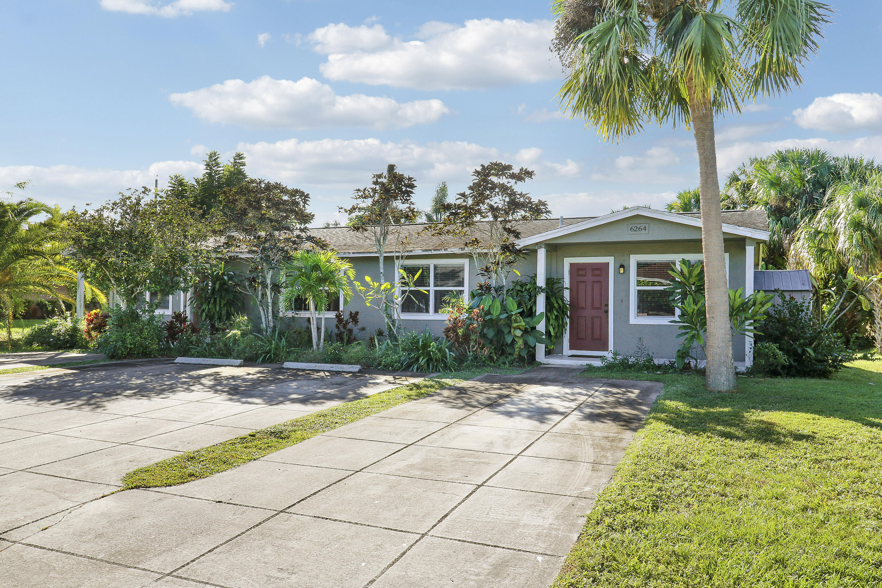 6264 Allen Street Jupiter, FL 33458 - Photo 2 of 27 a view of a house with a yard and palm trees