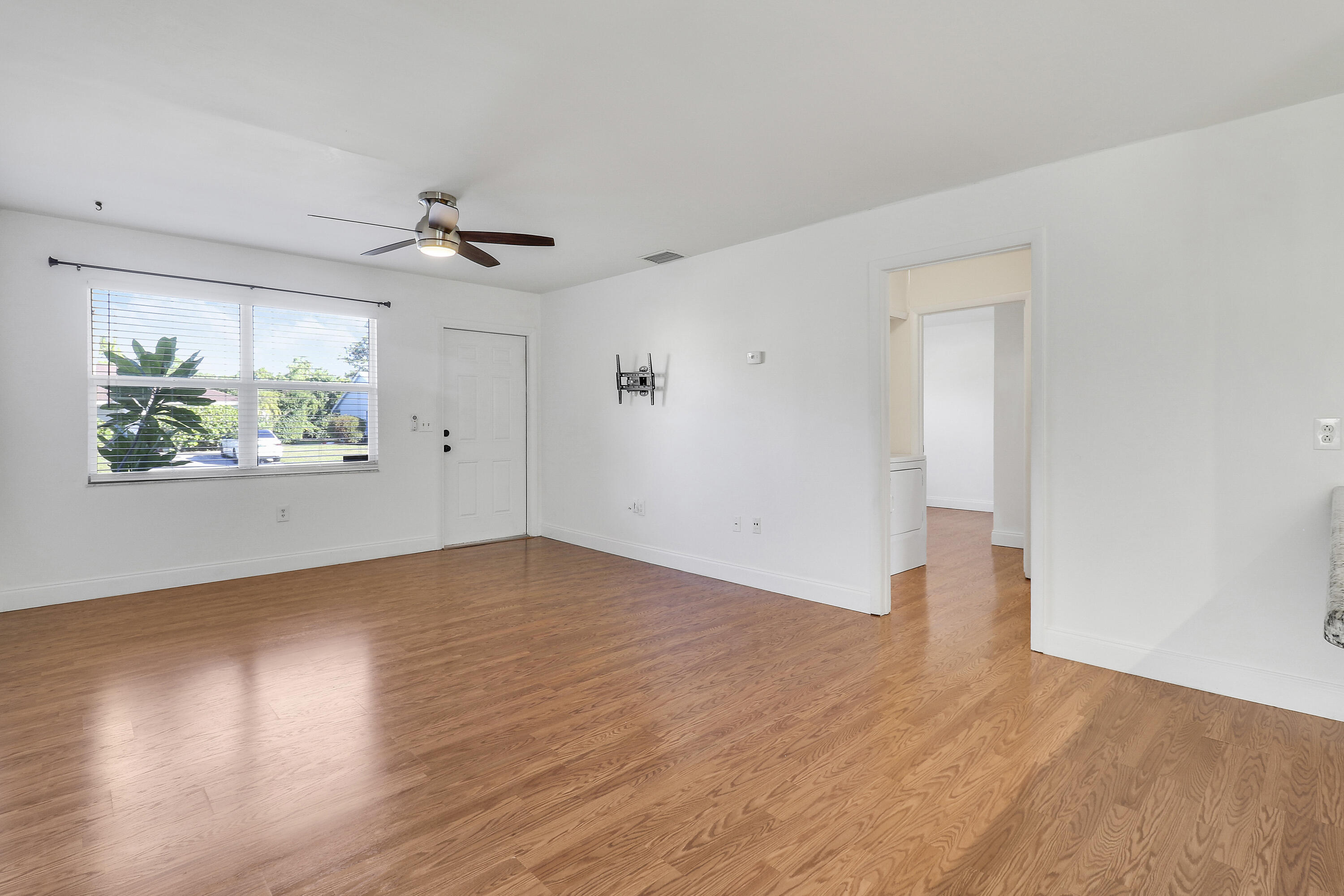 6264 Allen Street Jupiter, FL 33458 - Photo 21 of 27 an empty room with wooden floor and windows