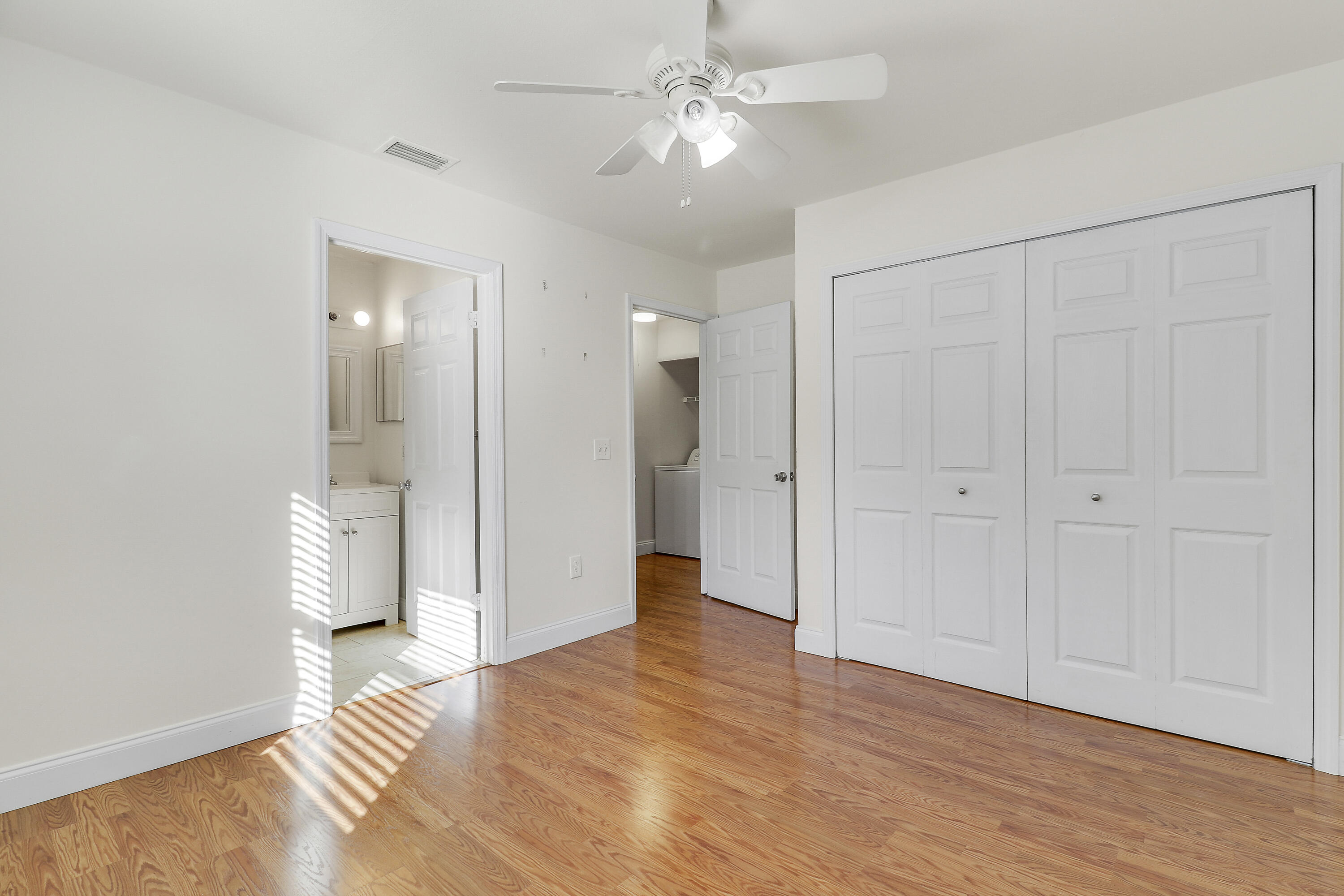 6264 Allen Street Jupiter, FL 33458 - Photo 23 of 27 wooden floor in an empty room with a bathroom