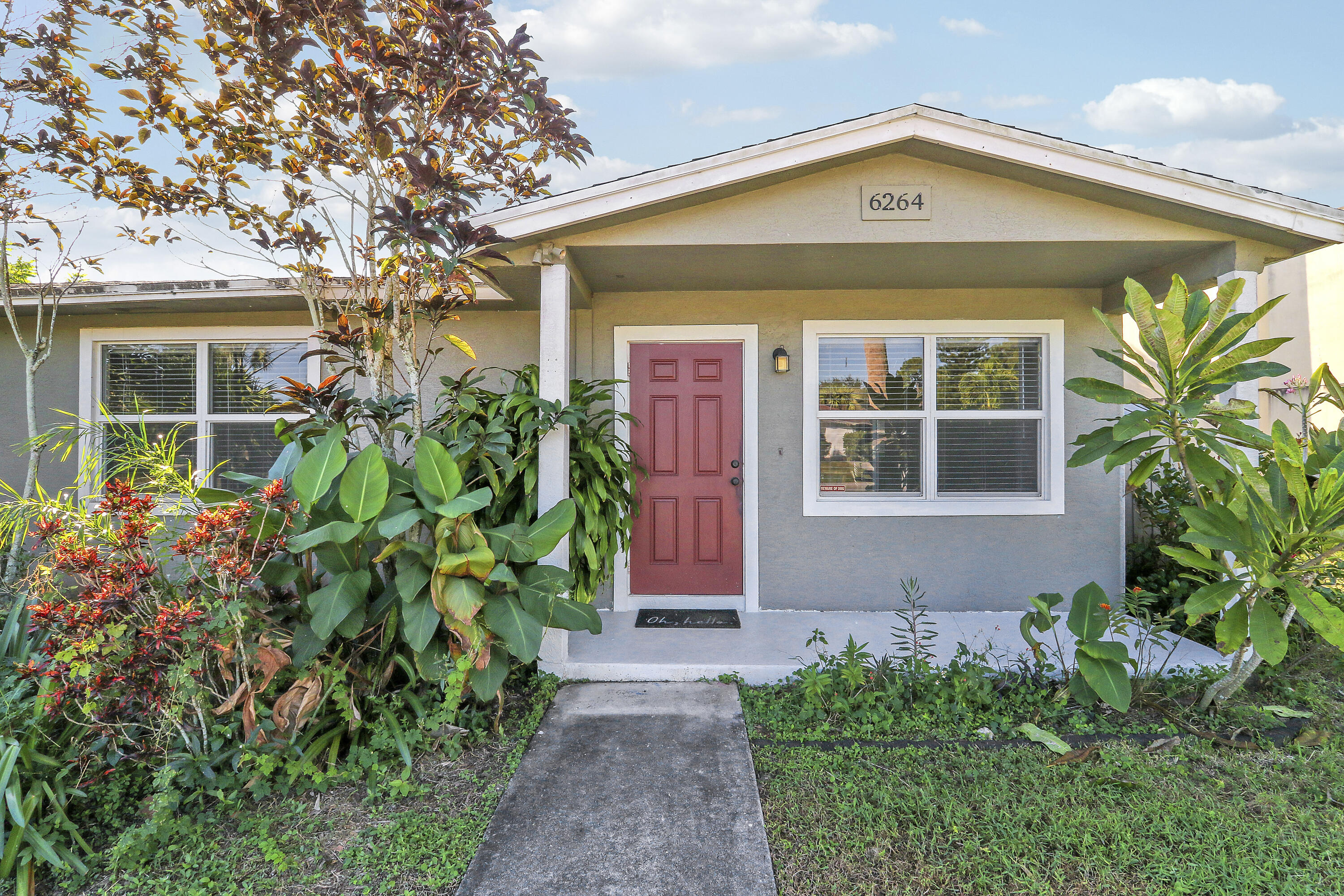 6264 Allen Street Jupiter, FL 33458 - Photo 3 of 27 a front view of a house with garden