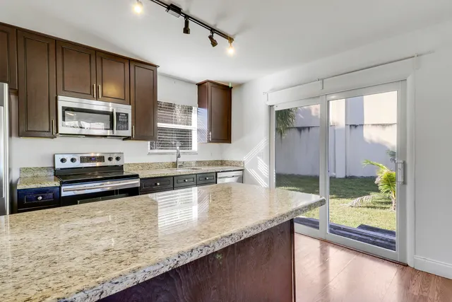 a kitchen with stainless steel appliances granite countertop a sink refrigerator and microwave