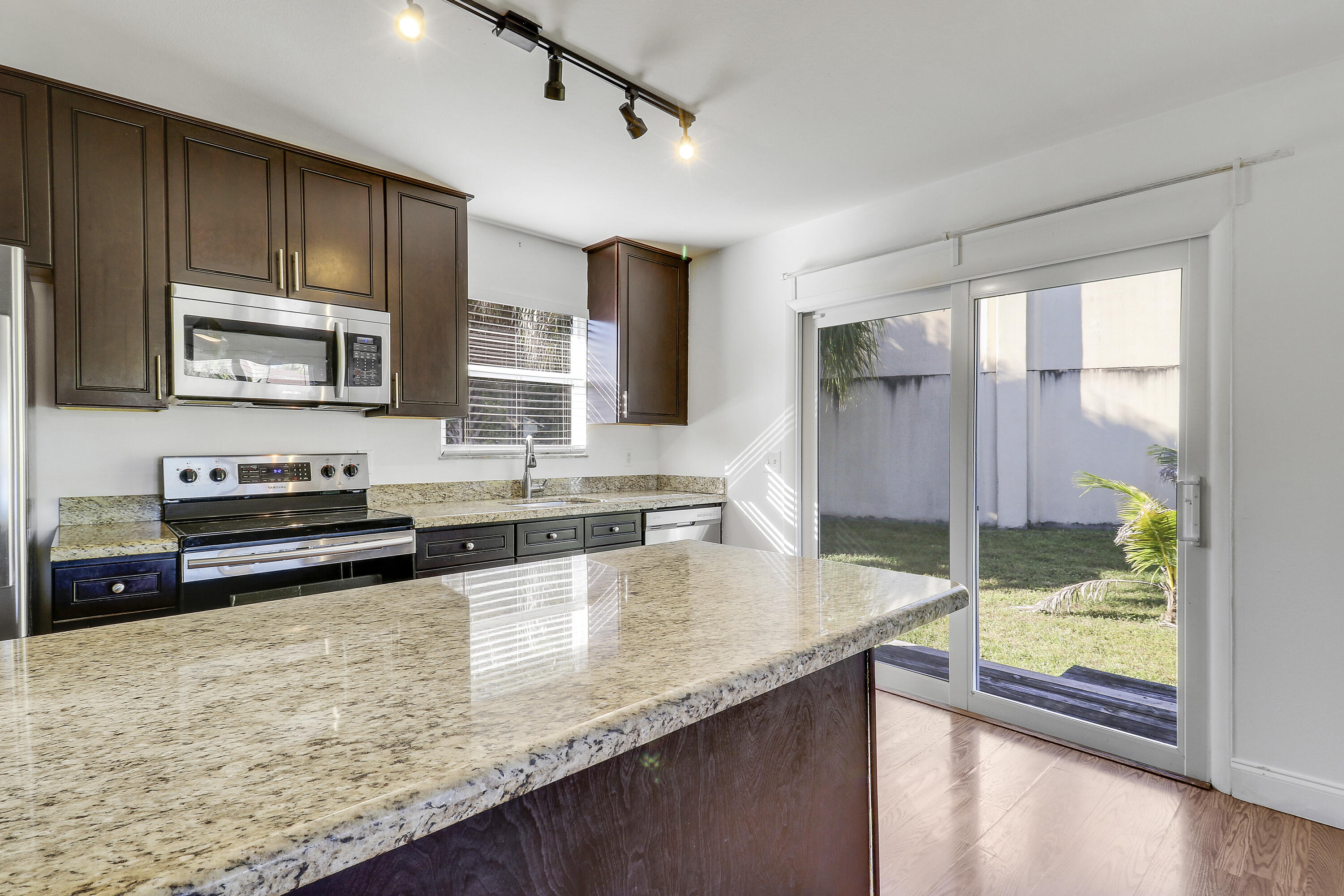 6264 Allen Street Jupiter, FL 33458 - Photo 9 of 27 a kitchen with stainless steel appliances granite countertop a stove a sink and a microwave
