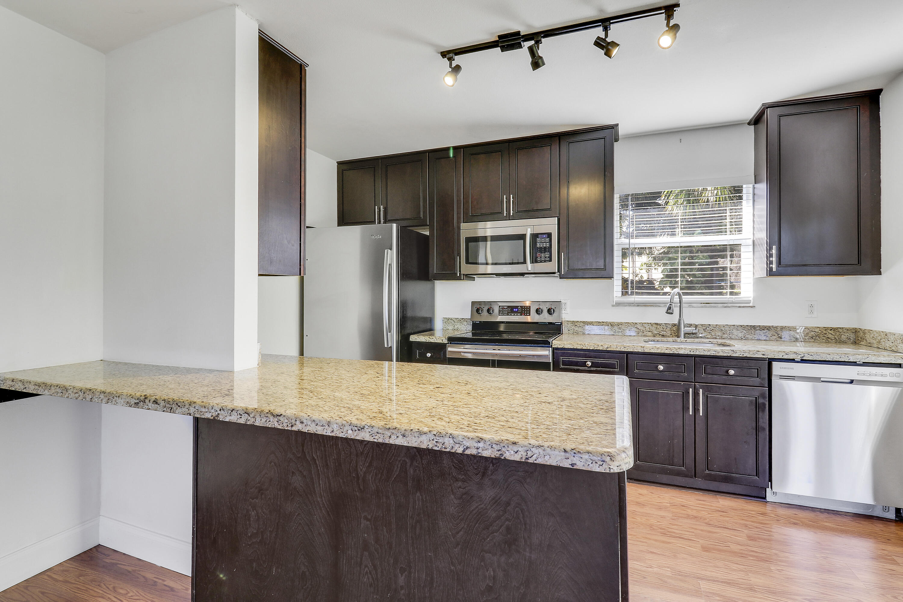 6264 Allen Street Jupiter, FL 33458 - Photo 10 of 27 a kitchen with stainless steel appliances granite countertop a sink refrigerator and microwave