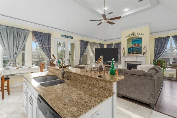 a kitchen with granite countertop a sink a counter top space and living room area