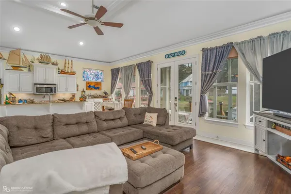 a living room with furniture a flat screen tv and a window