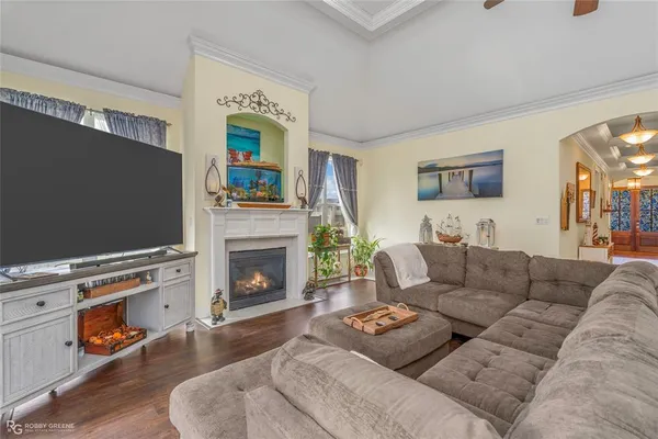 a living room with furniture a flat screen tv and a fireplace