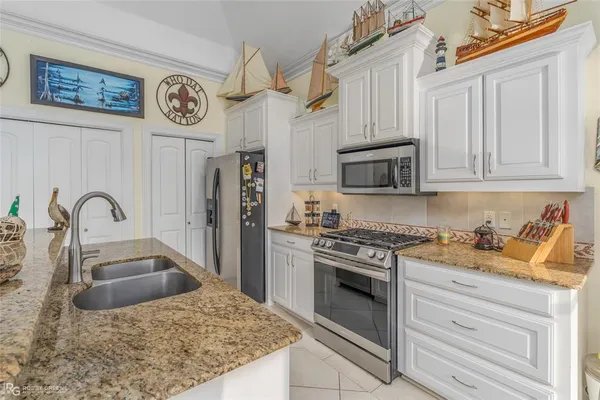 a kitchen with stainless steel appliances granite countertop a stove a sink and a microwave