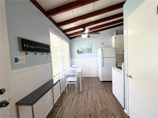 a kitchen with a refrigerator and table chairs