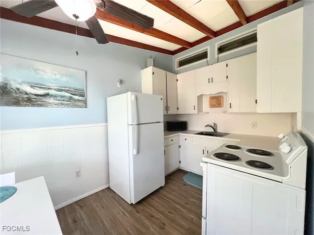 a kitchen with a refrigerator a stove top oven a white counter top and a floors