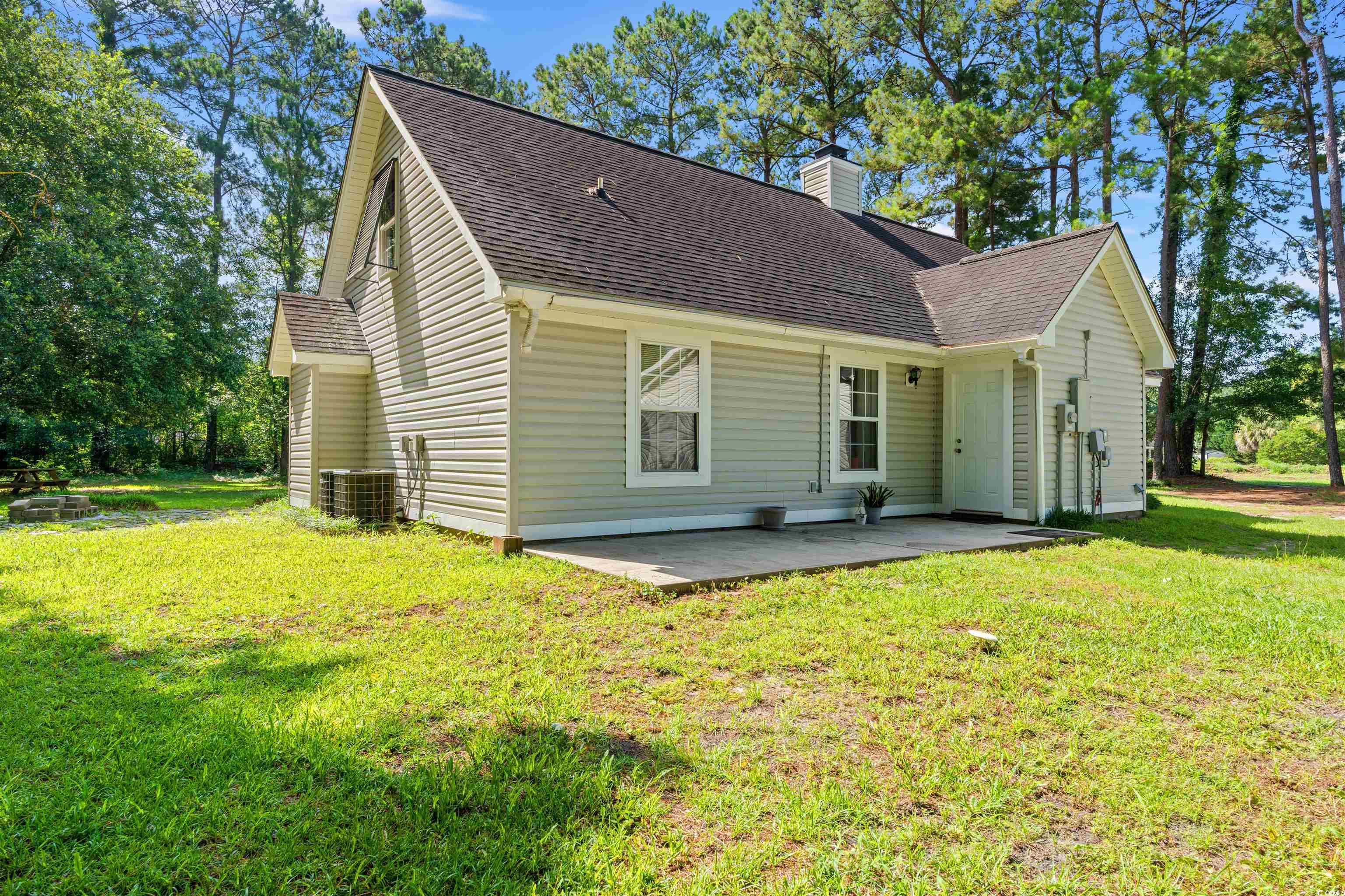938 Fox Hollow Road Conway, SC 29526 - Photo 25 of 39 Rear view of house with roof with shingles, a chimney, a patio area, and a lawn