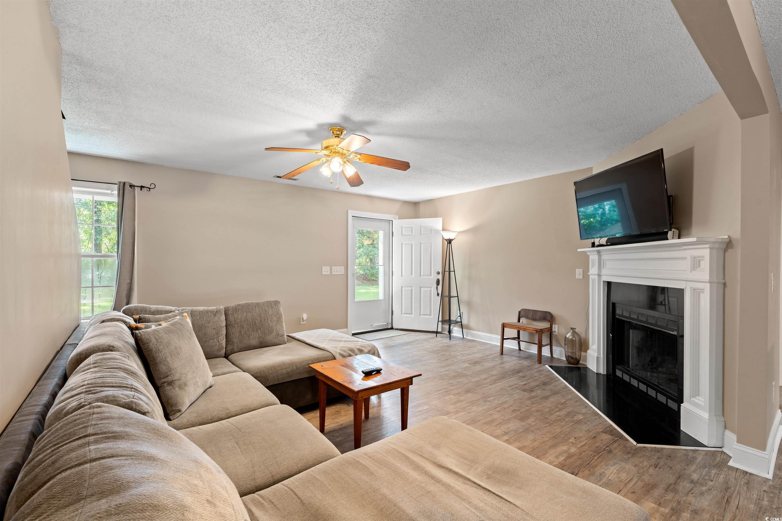 938 Fox Hollow Road Conway, SC 29526 - Photo 4 of 39 Living room with a fireplace, ceiling fan, a textured ceiling, and wood finished floors