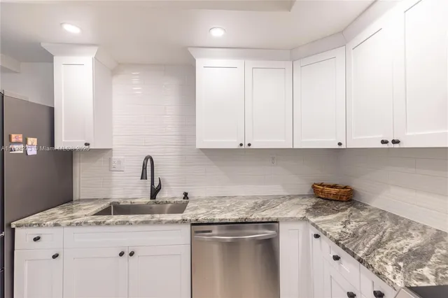 a kitchen with stainless steel appliances granite countertop a sink stove and cabinets
