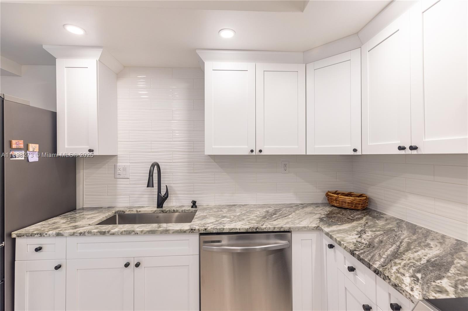 525 North Ocean Boulevard, Unit 1820 Pompano Beach, FL 33062 - Photo 4 of 18 a kitchen with stainless steel appliances granite countertop a sink stove and cabinets