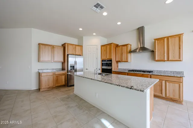 a large kitchen with granite countertop a sink and a stove top oven