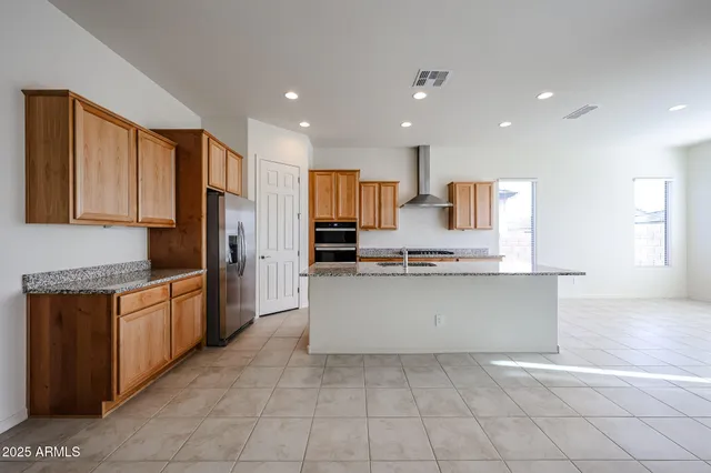 a large kitchen with stainless steel appliances lots of counter top space and wooden floor