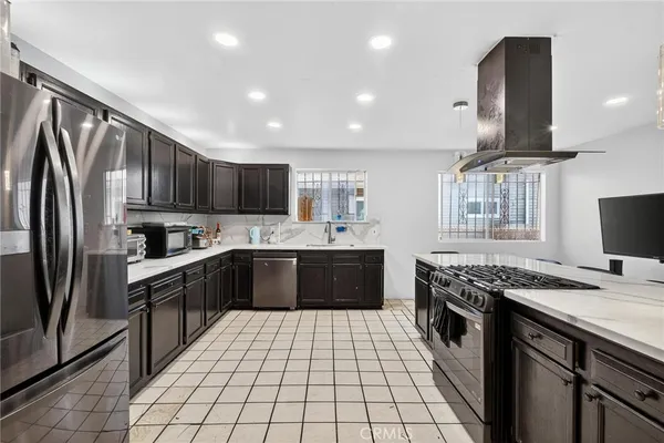 a kitchen with stainless steel appliances granite countertop a sink stove a refrigerator and a microwave