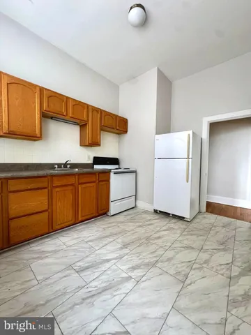 a view of kitchen with stainless steel appliances granite countertop a stove a sink and a refrigerator