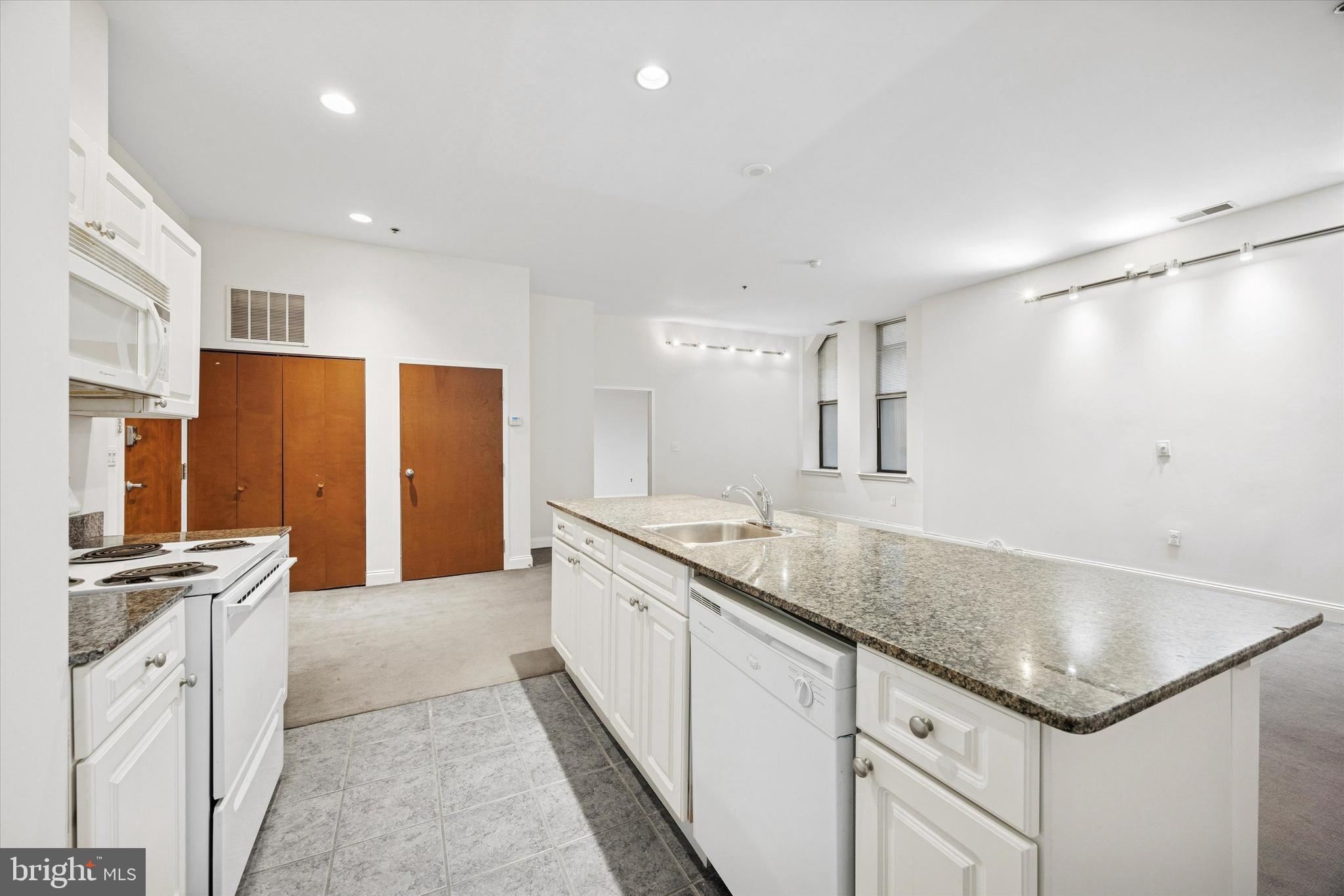 1001 Chestnut Street, Unit 205W Philadelphia, PA 19103 - Photo 5 of 25 a kitchen with granite countertop a sink stove and refrigerator