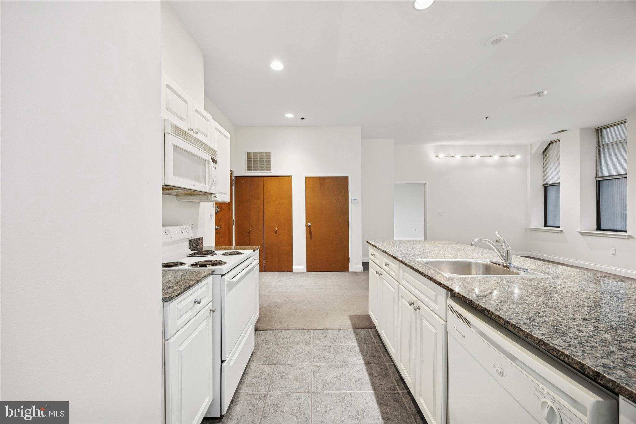 1001 Chestnut Street, Unit 205W Philadelphia, PA 19103 - Photo 6 of 25 a large kitchen with stainless steel appliances granite countertop a sink stove and refrigerator