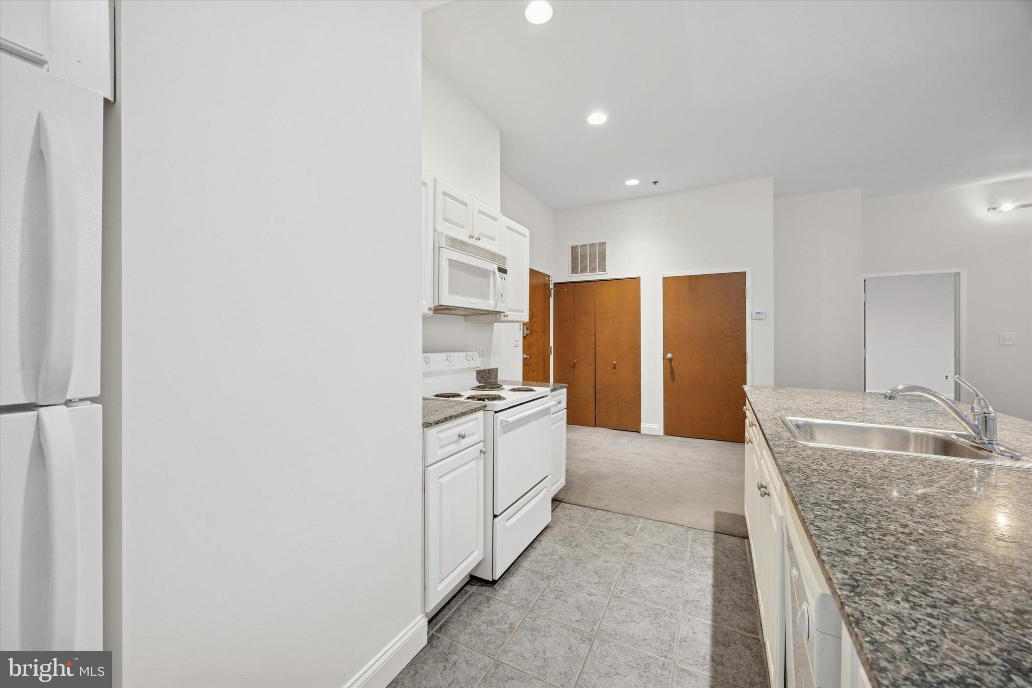 1001 Chestnut Street, Unit 205W Philadelphia, PA 19103 - Photo 7 of 25 a kitchen with stainless steel appliances granite countertop a refrigerator and a sink