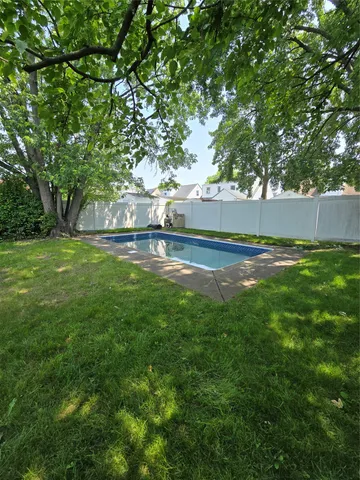 a view of yard with swimming pool and green space
