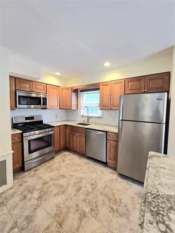 a kitchen with stainless steel appliances granite countertop a refrigerator sink and stove