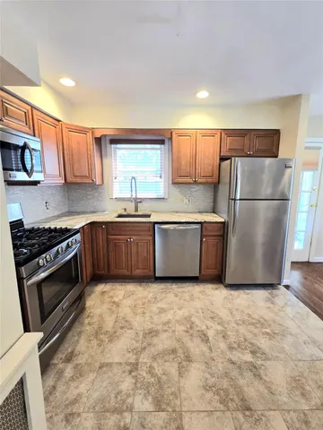 a kitchen with stainless steel appliances granite countertop a stove a sink and a refrigerator