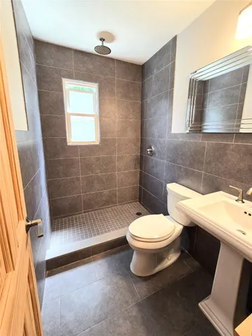 a bathroom with a toilet and a shower