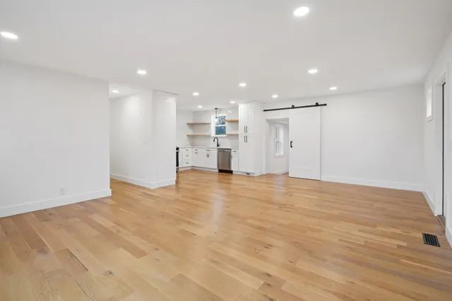 a view of empty room with wooden floor