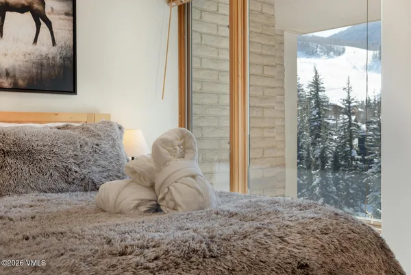 a large bed sitting in a bedroom next to a window