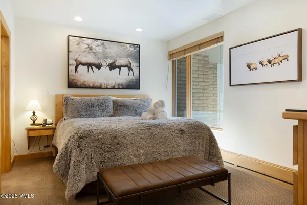 a bedroom with a bed and painting on the wall