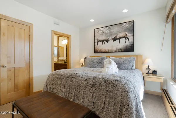a bedroom with a bed and painting on the wall