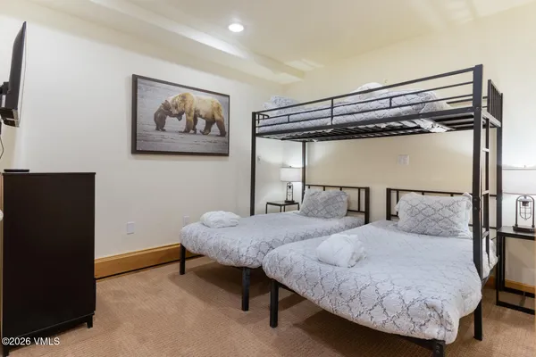 a bedroom with a bed and a painting on the wall