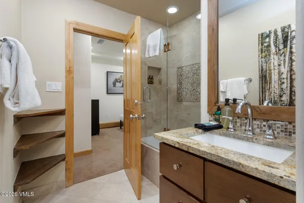 a bathroom with a granite countertop sink and a mirror