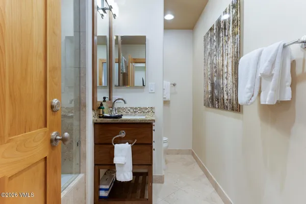 a en suite bathroom with a granite countertop sink and a mirror