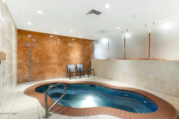 a room with wooden floor pool table and chairs