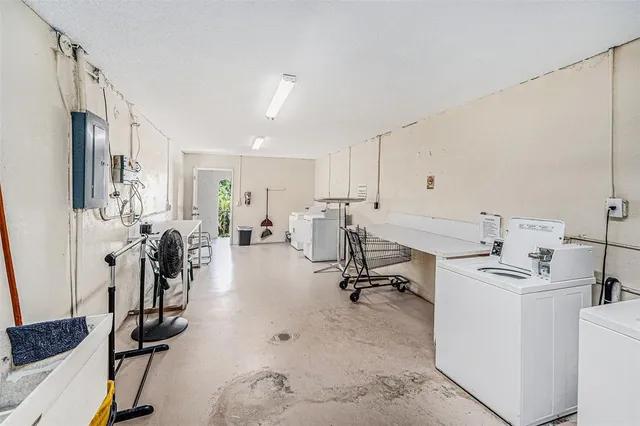 a living room with furniture a flat screen tv and kitchen view